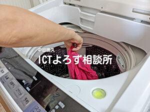 洗濯機から洗濯物を取り出す（ピンクのTシャツ１）の写真フリー素材